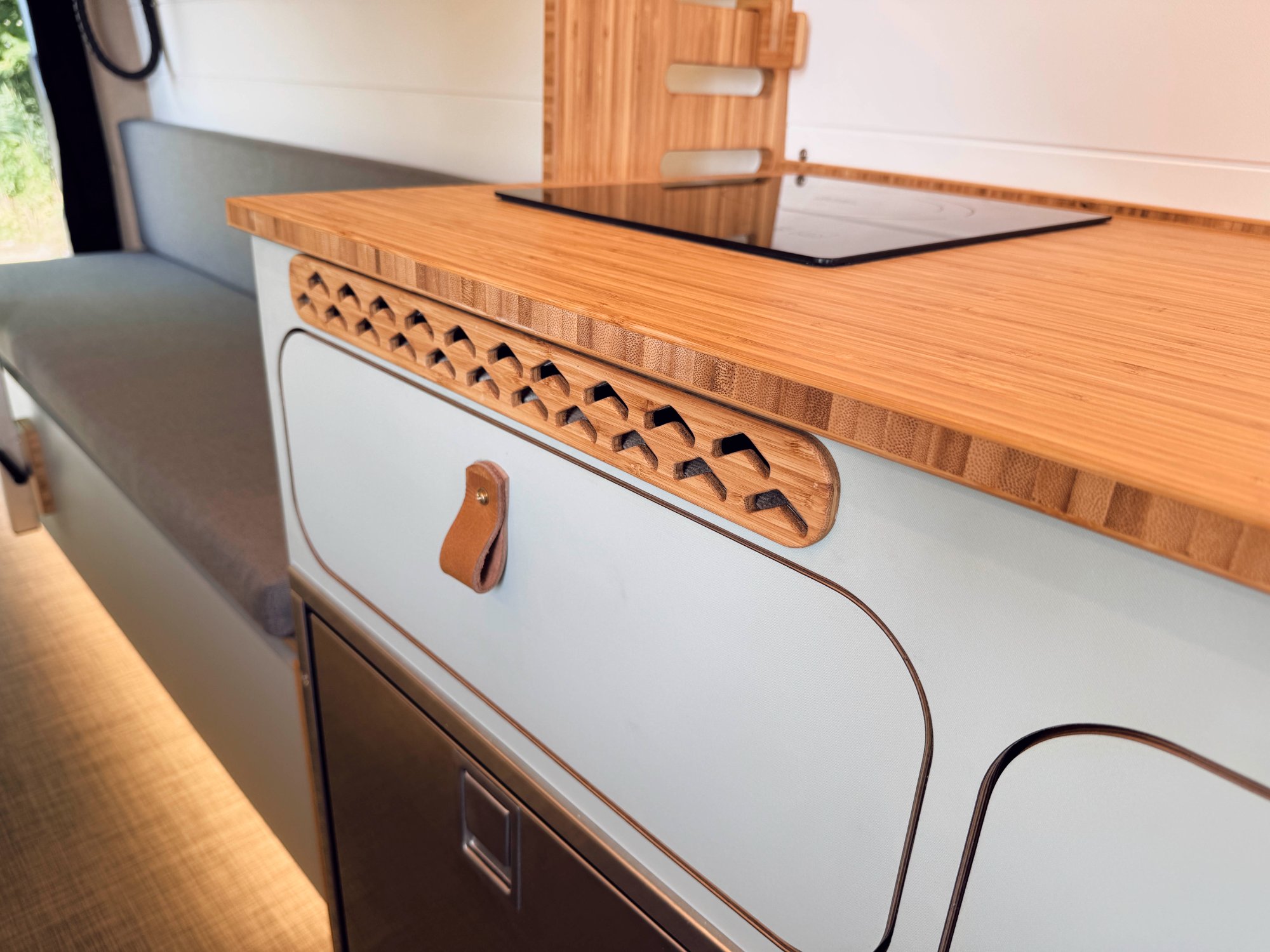 Loft — bamboo vent strip, leather pull, induction cooktop