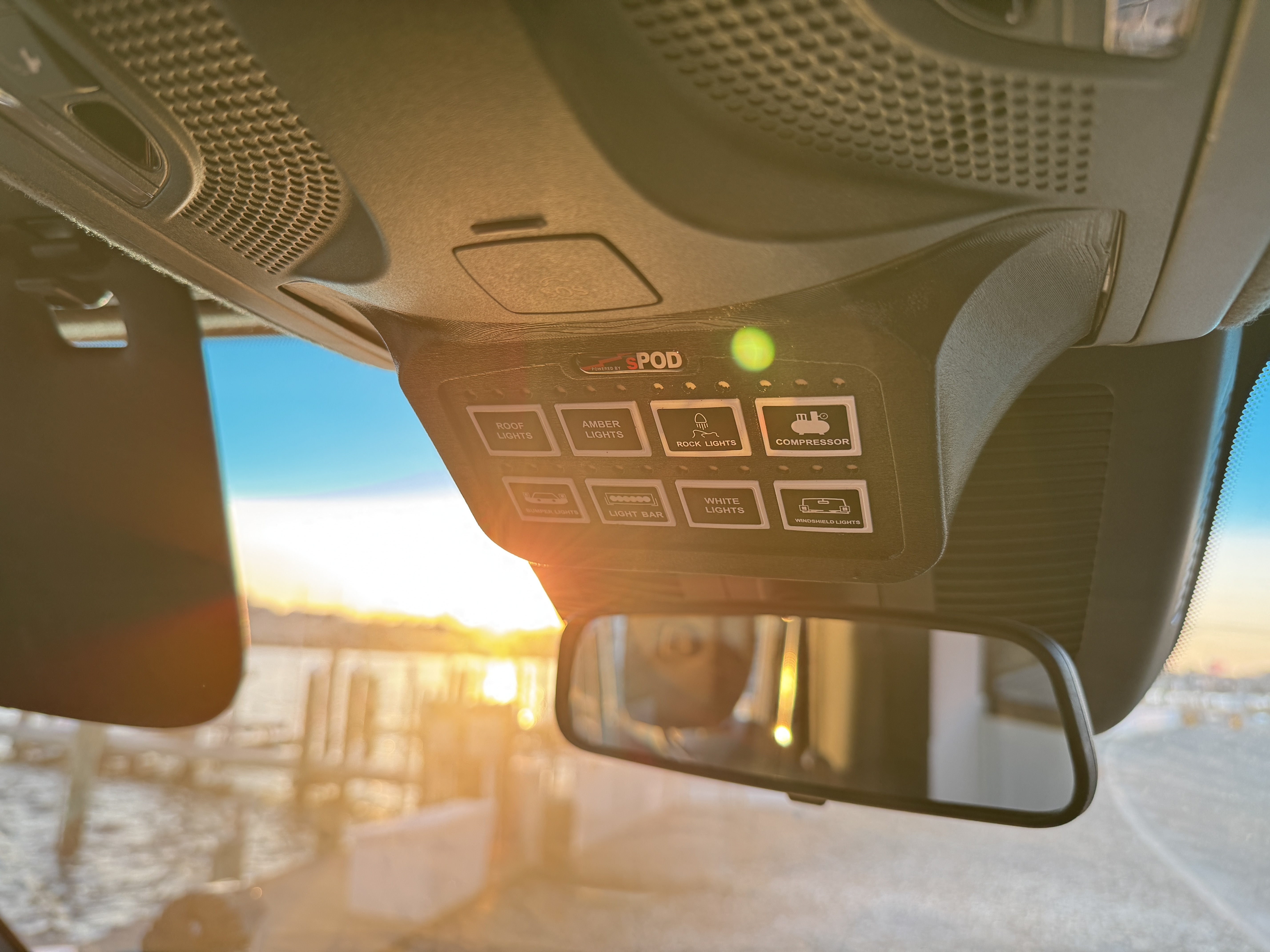 Baja Sprinter 170 4x4 — sPOD switch panel mounted to overhead console with controls for roof lights, amber lights, rock lights, compressor, bumper lights, light bar, white lights, and windshield lights