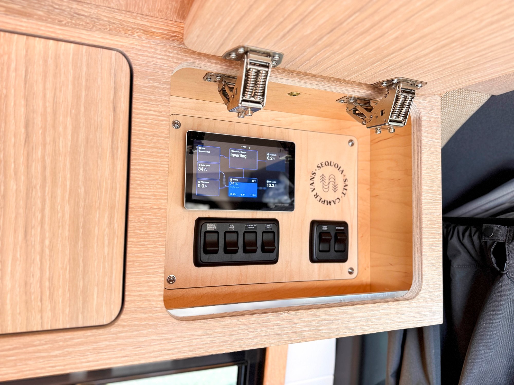 The Loft — branded Victron control panel with the laser-engraved Sequoia + Salt logo, set into the cabinetry