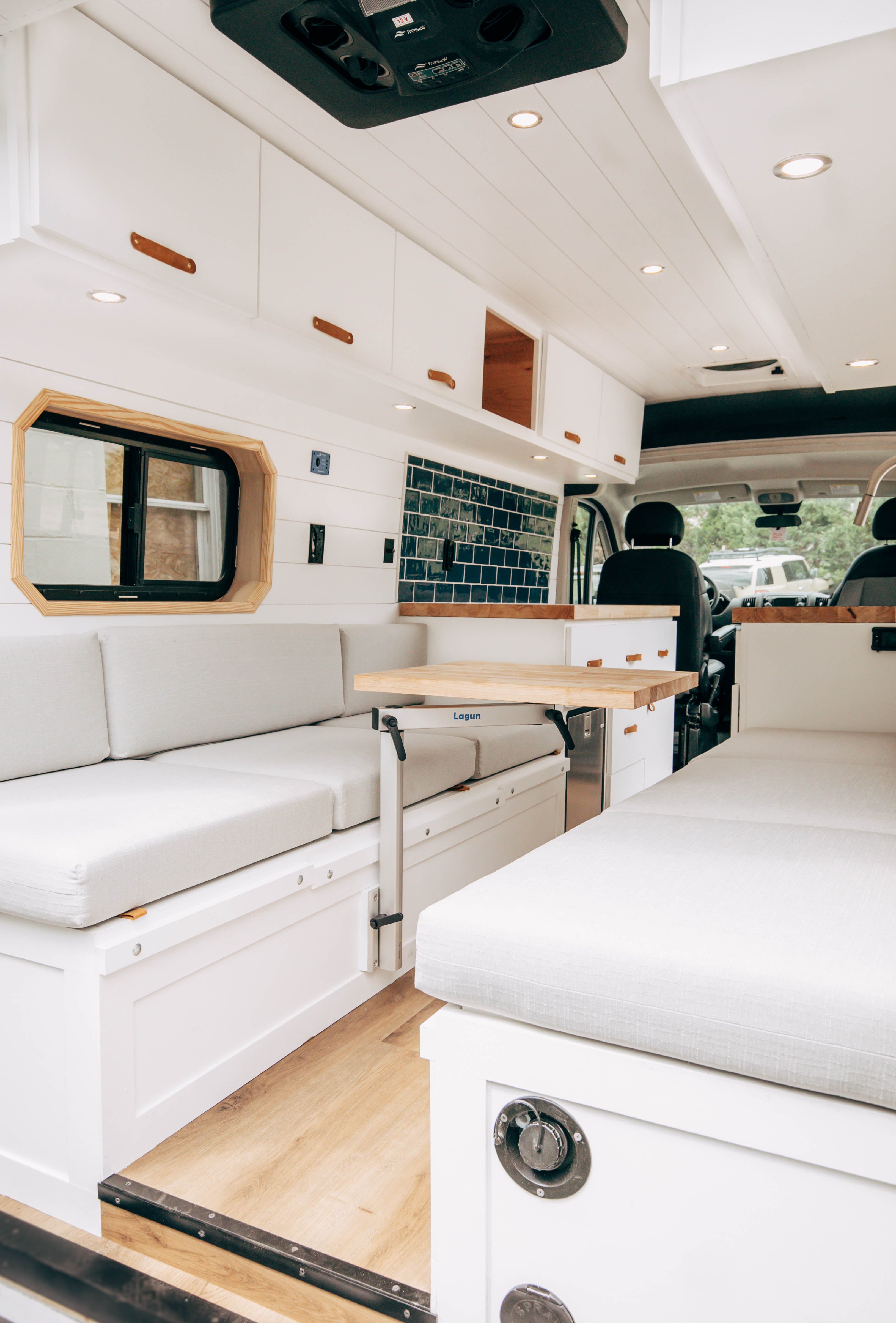Riverside ProMaster 159 campervan rear bench folded out into a bed with white cushions