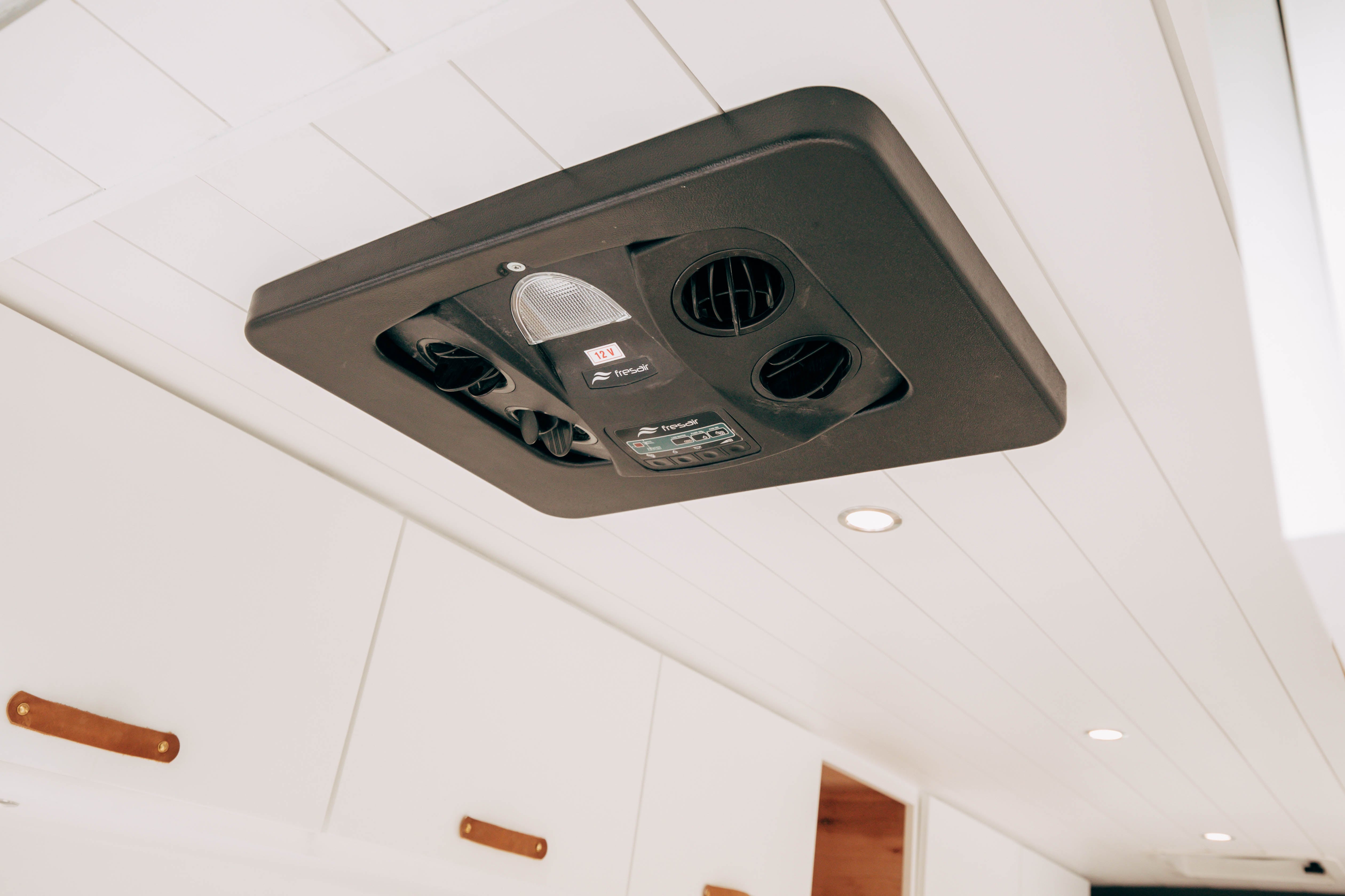 Riverside ProMaster 159 campervan roof fan set into the white paneled ceiling