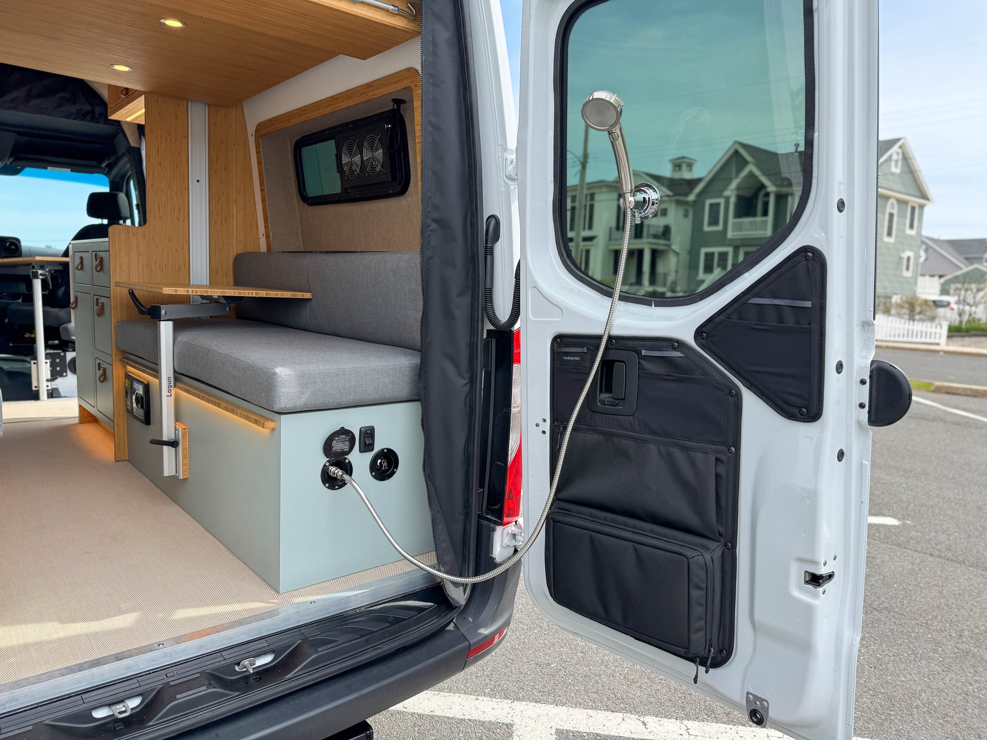The Scout — rear doors open on the grey Sprinter 144, convertible lounge and exterior shower