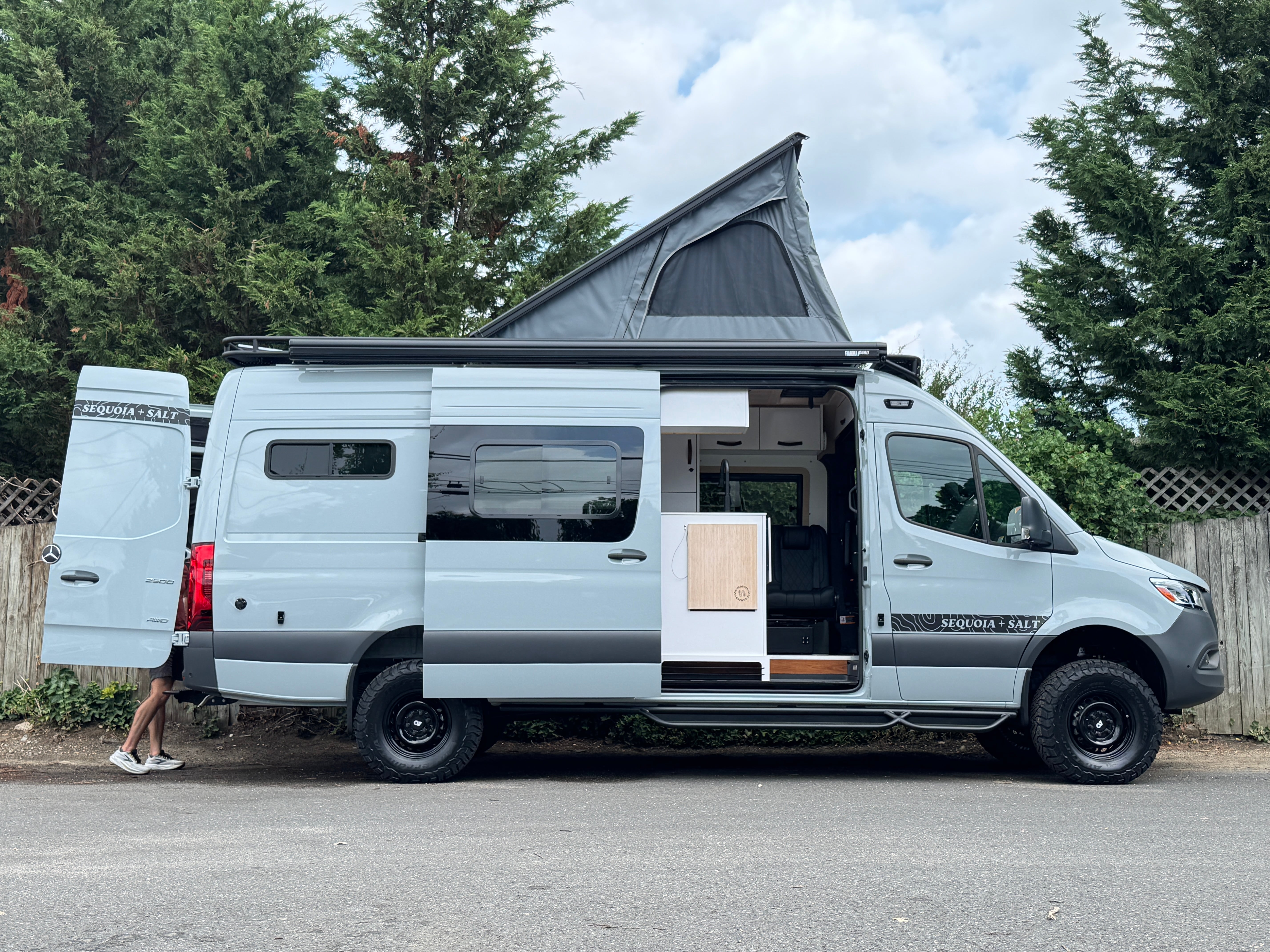 Skyrise Sprinter 170 campervan rear three-quarter with the pop-top up and side door open