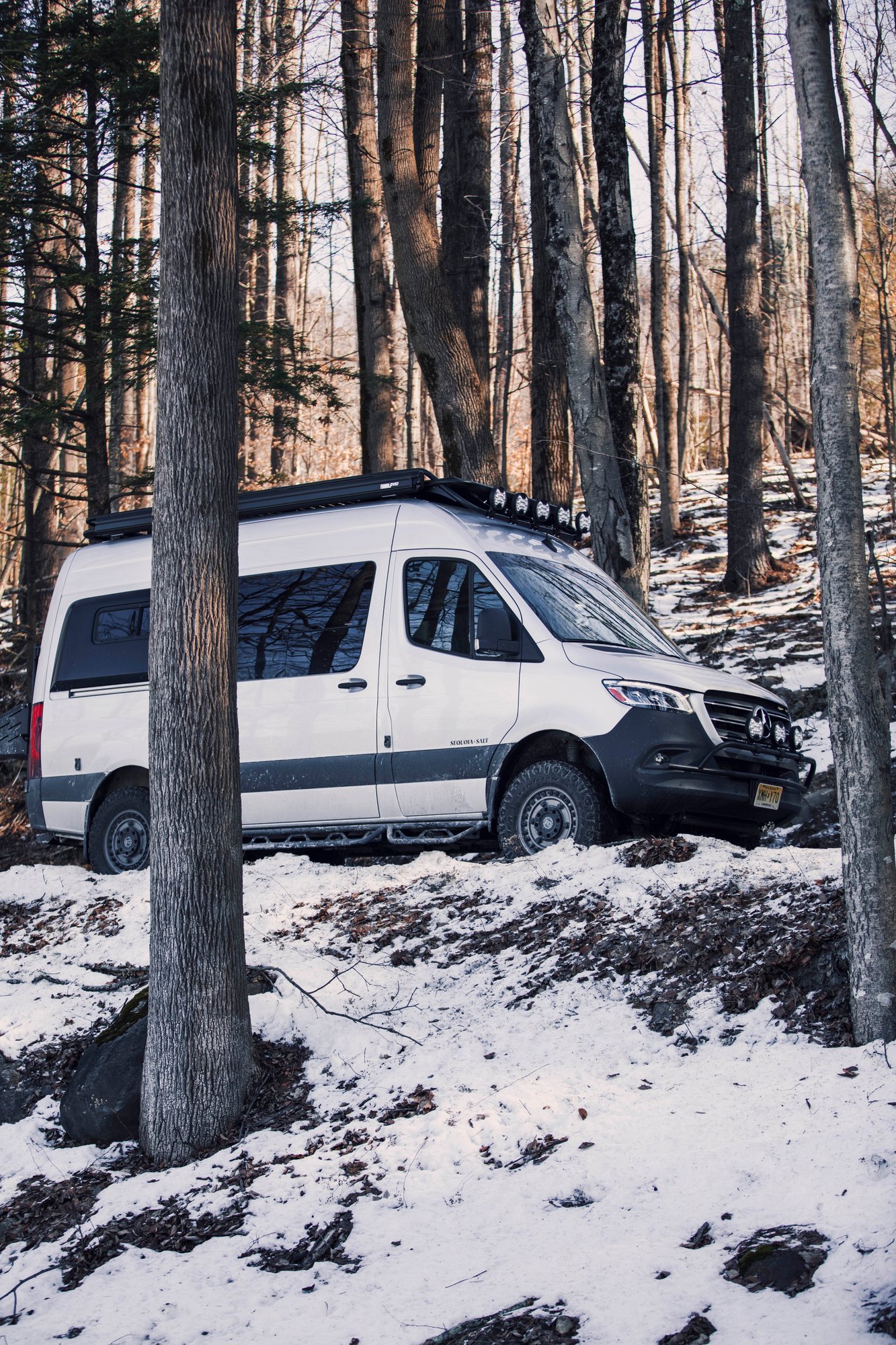 The Stoke — silver Sprinter 144 parked on a snowy forest trail