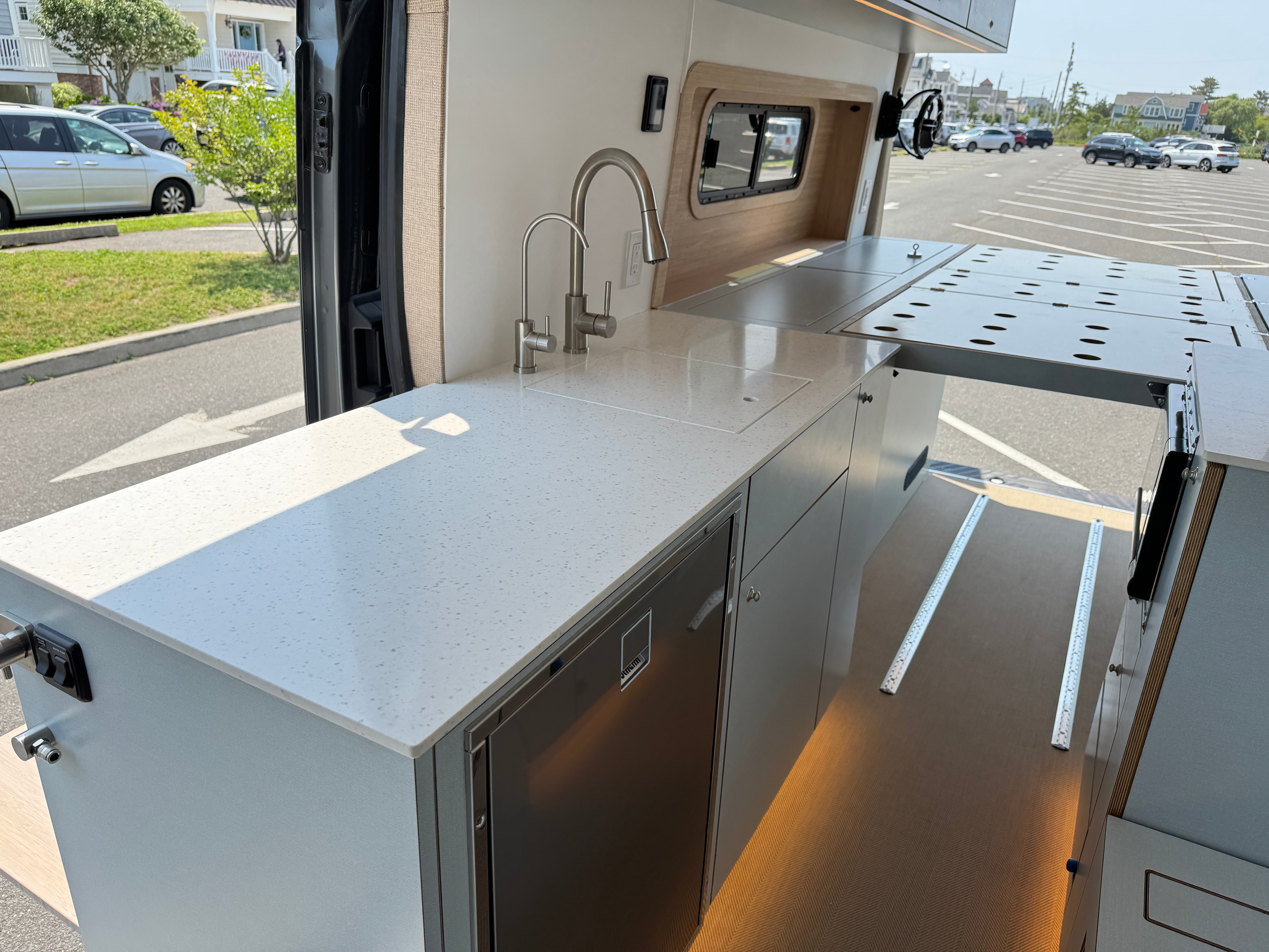 Super Lounger Ford Transit galley with a white waterfall countertop and stainless sink