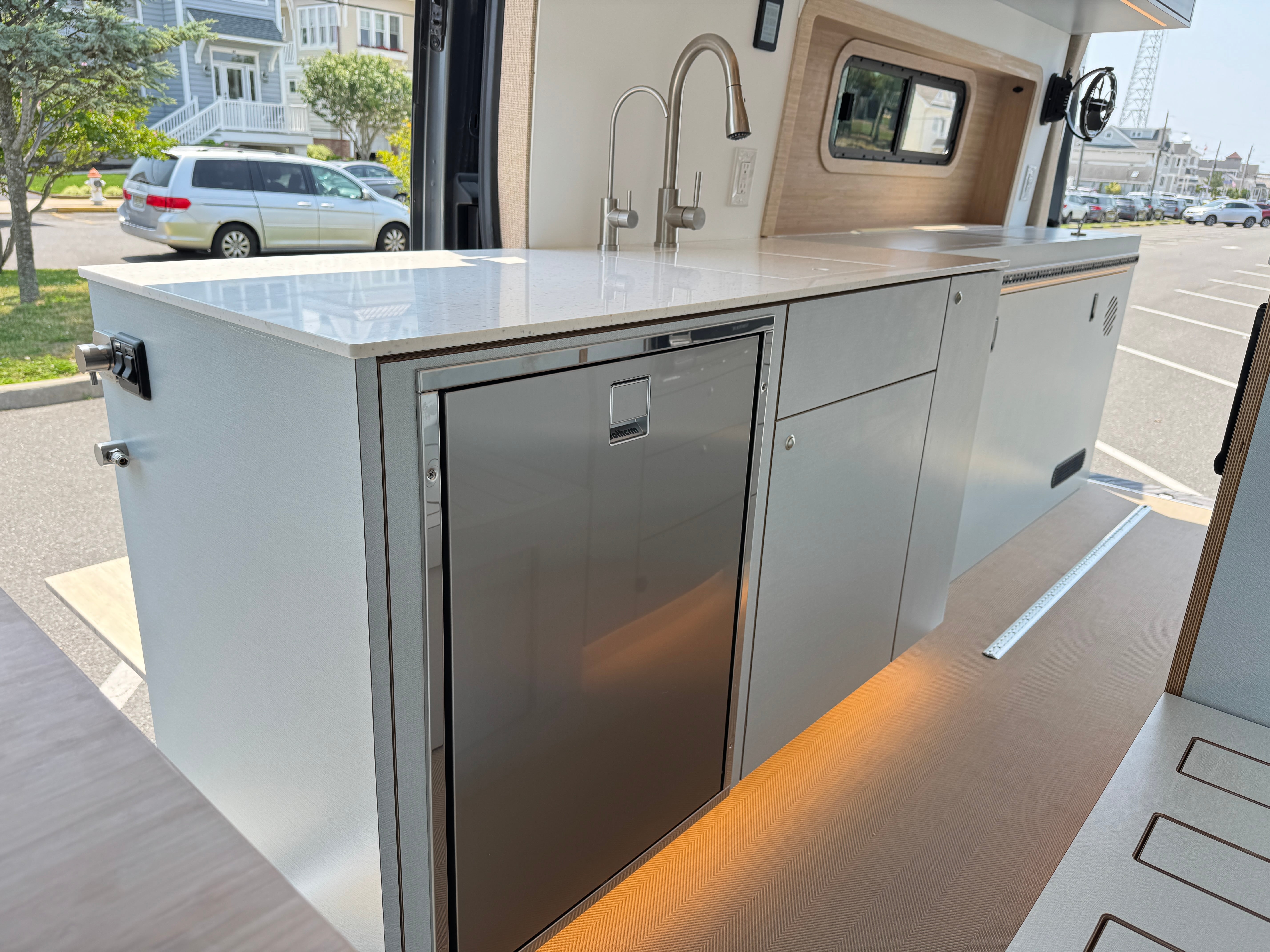 Super Lounger Ford Transit galley island with a white counter and stainless sink