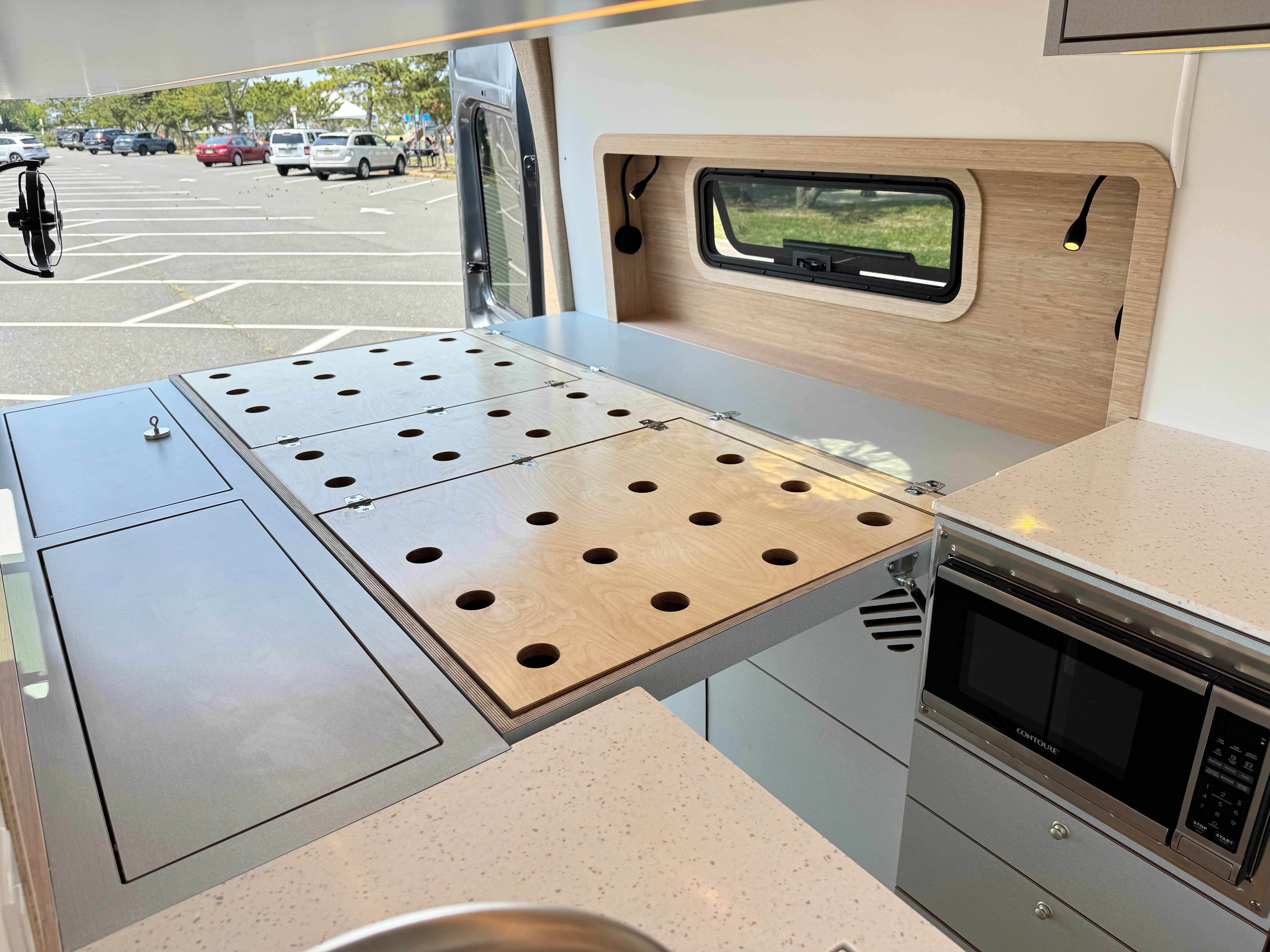 Super Lounger Ford Transit galley counter with a built-in microwave beside a window