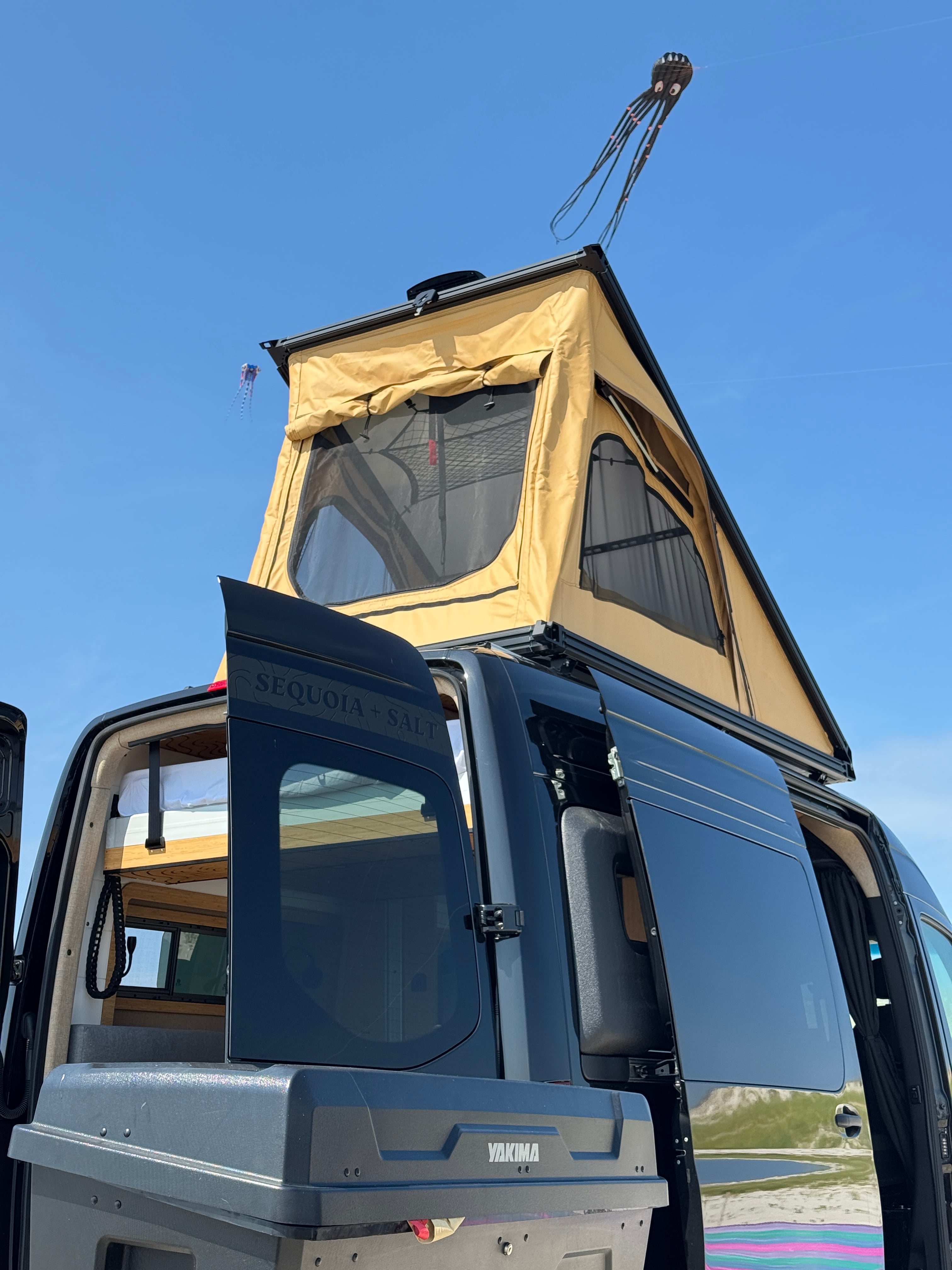 The Don Sprinter 144 campervan with its pop-top penthouse roof extended and rear doors open