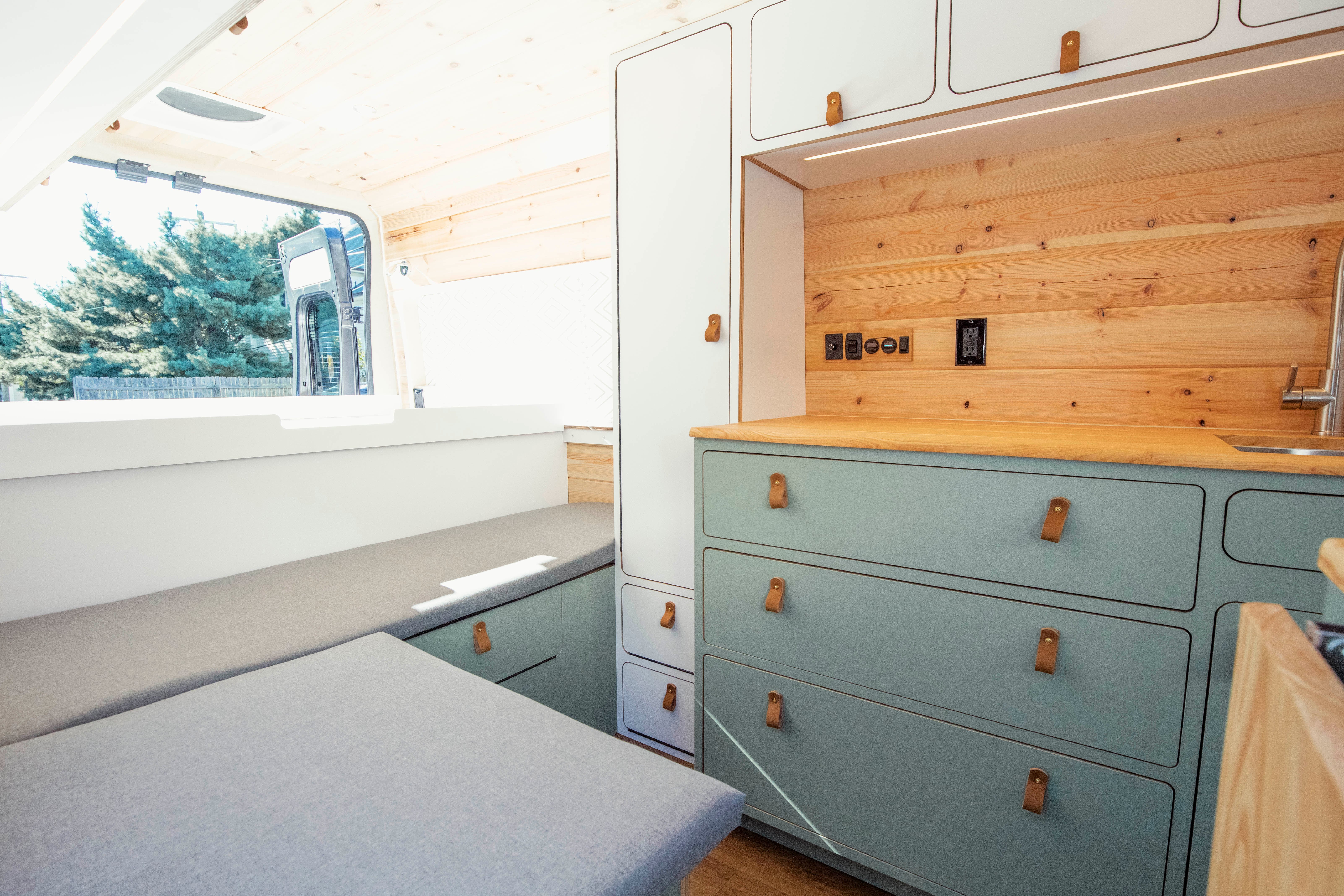 Wild Flower — Ram ProMaster 159, sage galley interior with sliding bed