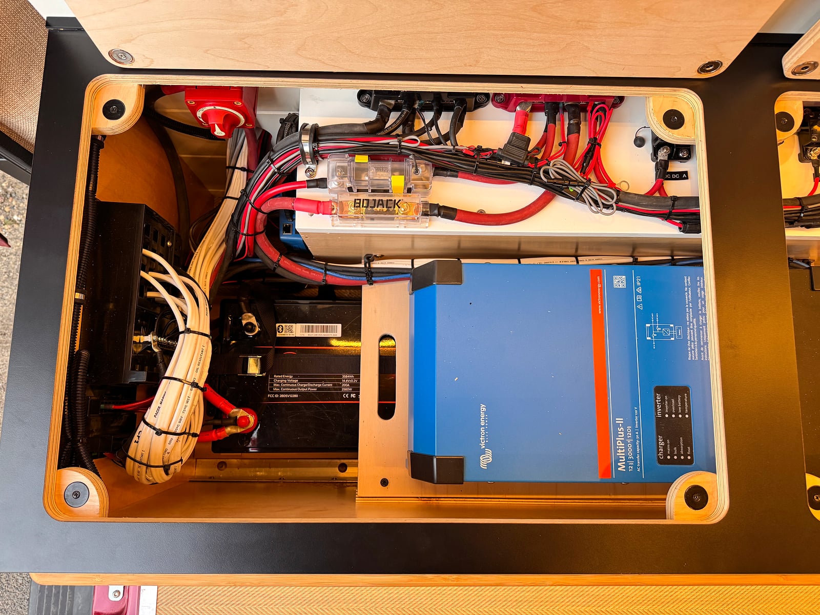 Bobal Mobile Salon — Victron MultiPlus inverter, lithium battery, and wiring in the baltic-birch power bay