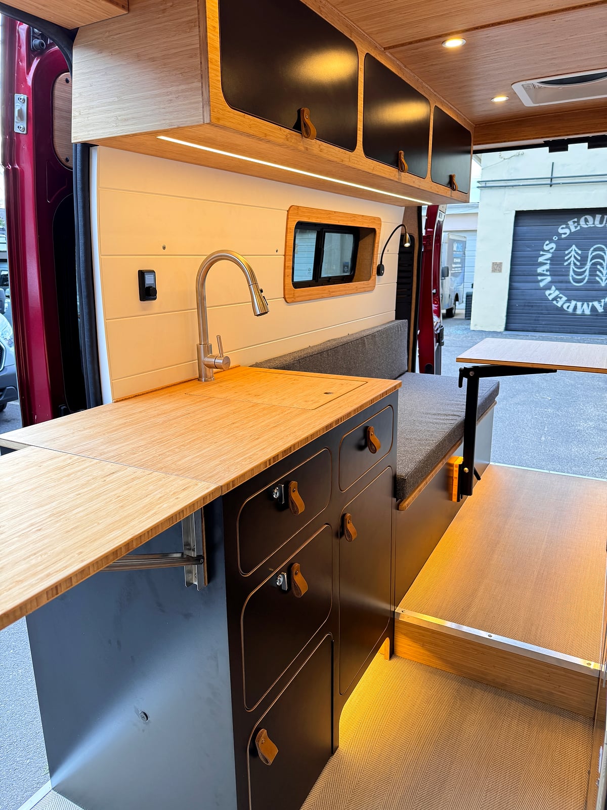 Bobal Mobile Salon — driver-side bamboo galley with sink, drawers, and pop-up countertop extension