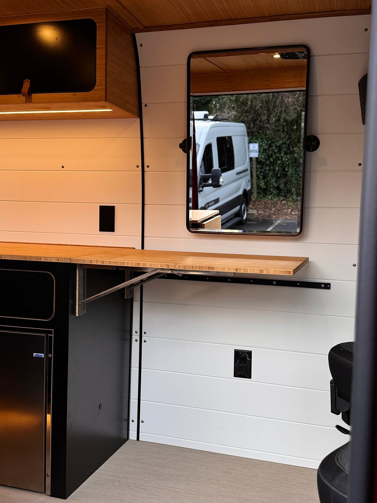 Bobal Mobile Salon — styling station with wall-mounted beauty mirror, bamboo countertop, and styling chair on open floor