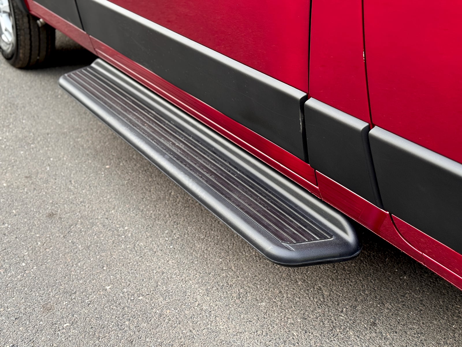 Bobal Mobile Salon — matte-black running board step on the red ProMaster for easy side-door entry