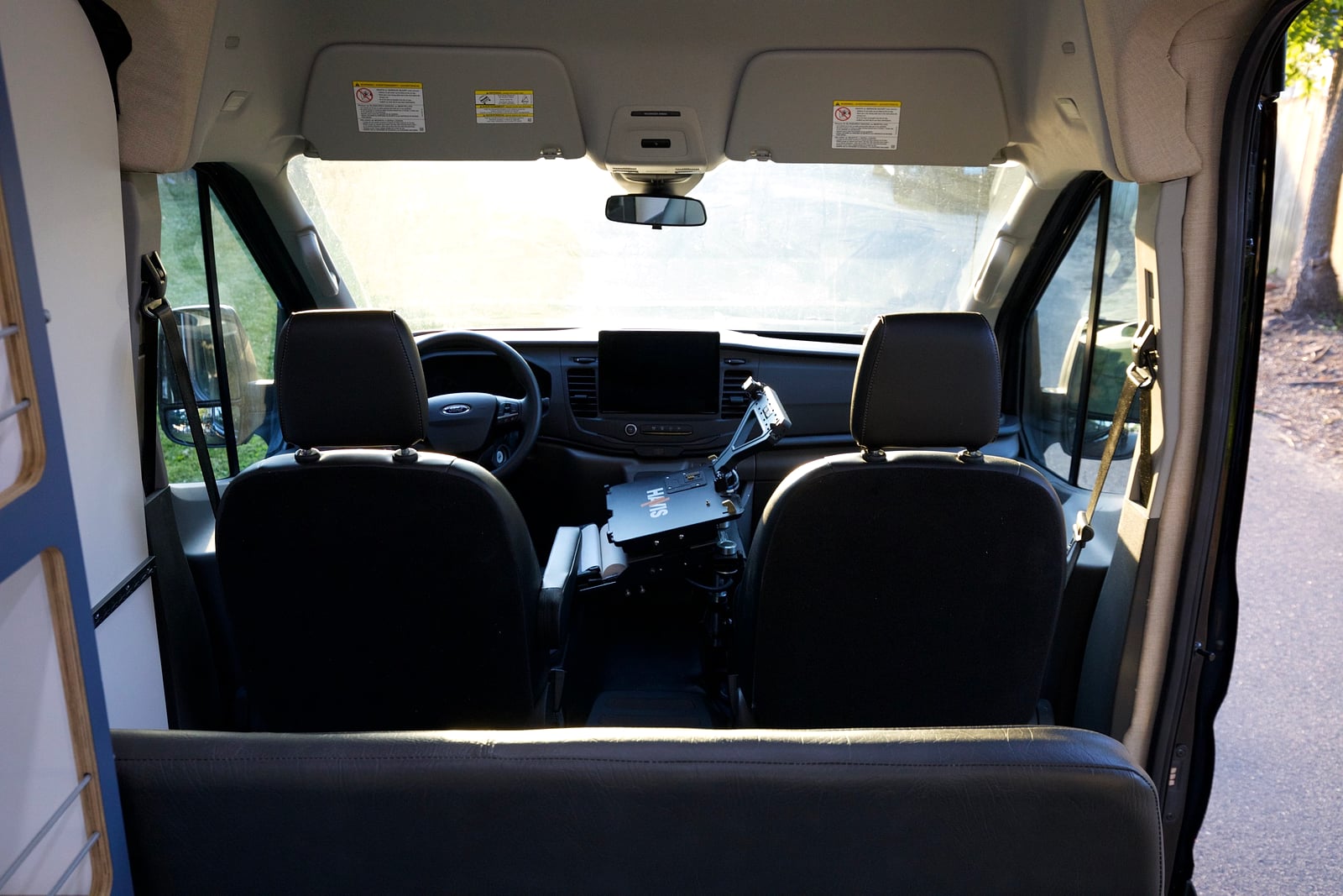 Northampton DCC electric Transit fleet — view forward from the cabin into the Ford Transit cab with a mounted laptop, ready to respond