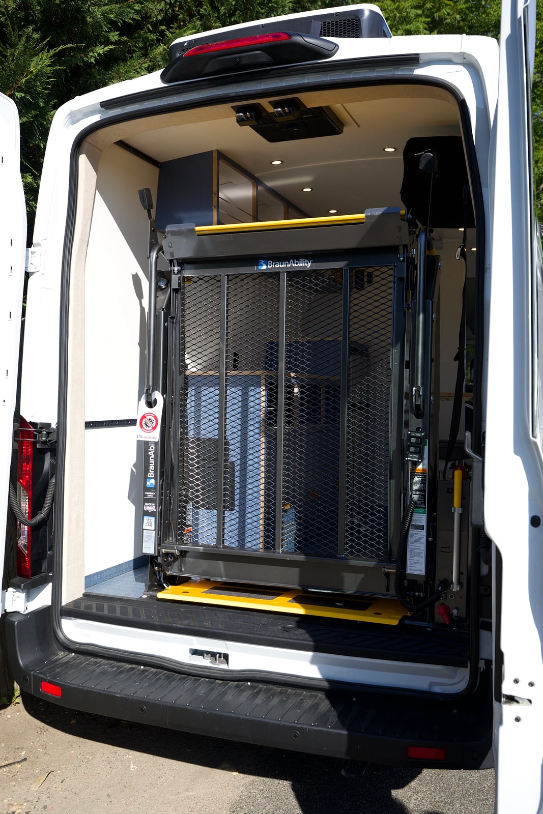Northampton DCC electric Transit fleet — rear doors open with a powered wheelchair lift deployed for accessible entry