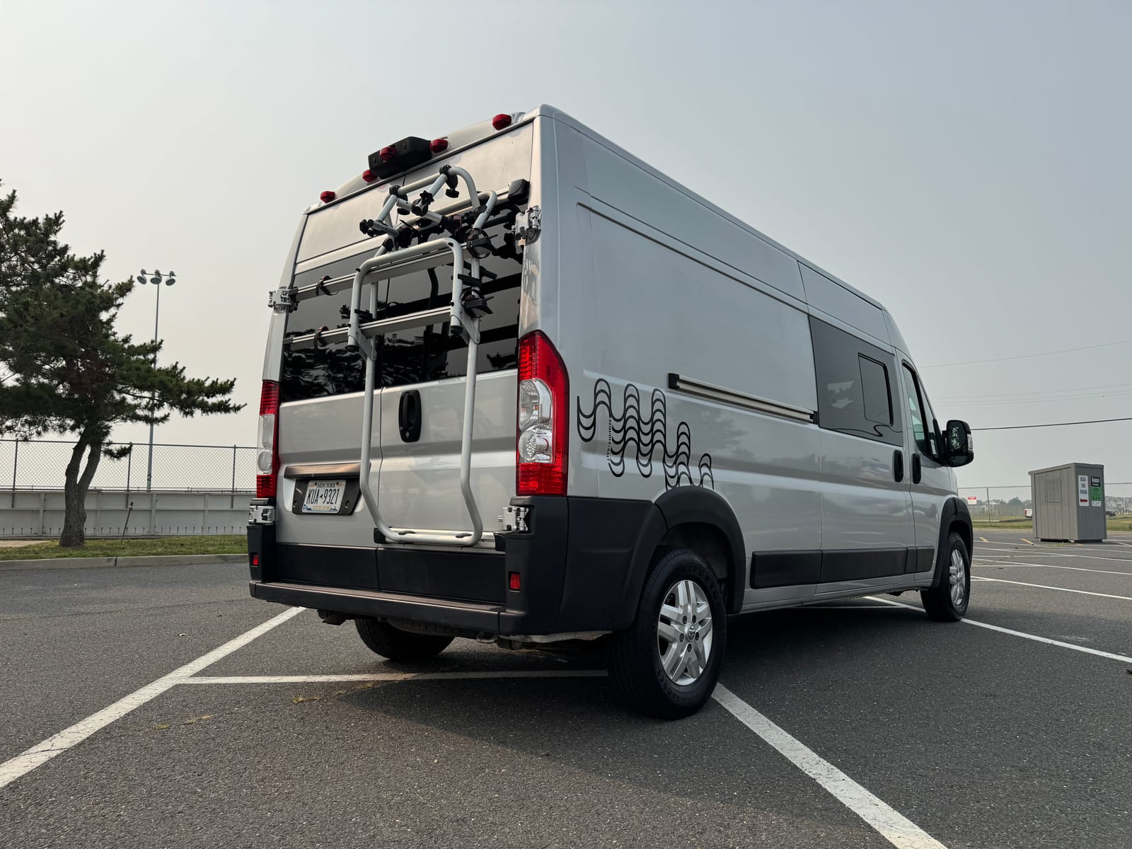 Rear three-quarter view showing the roof rack and rear-door bike rack