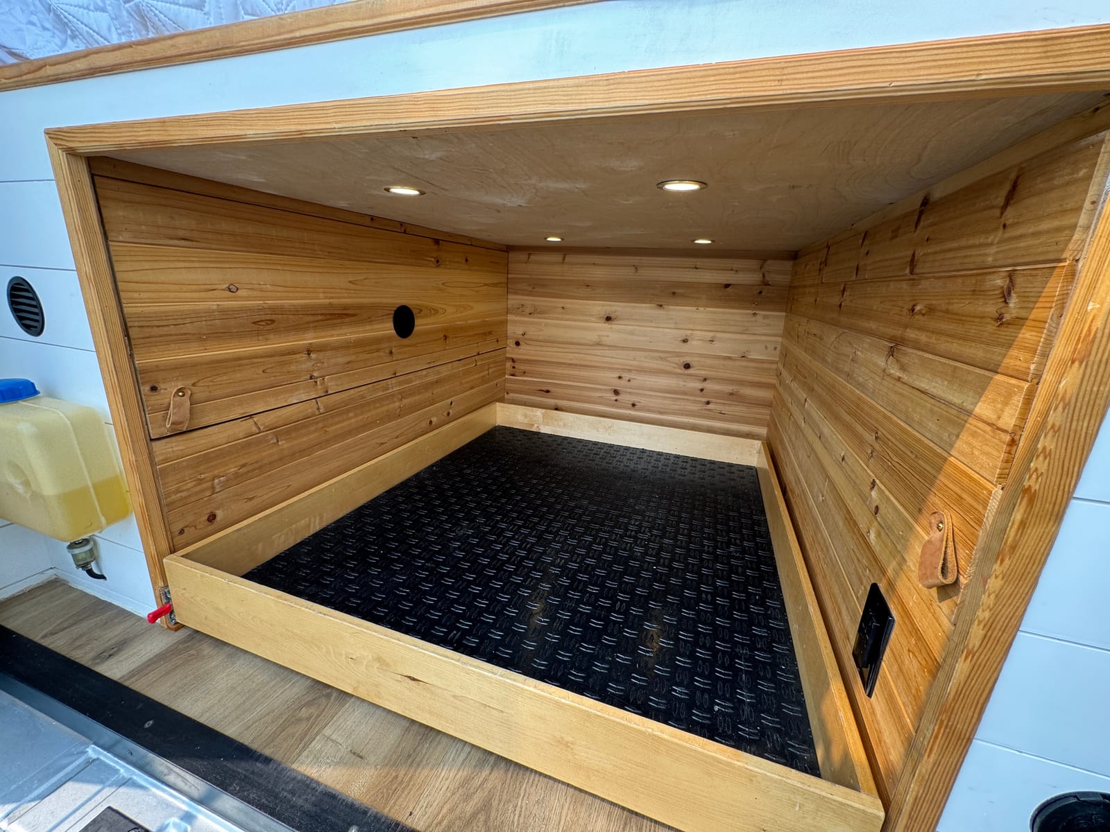 Cedar-lined gear garage under the bed with a rubber mat floor