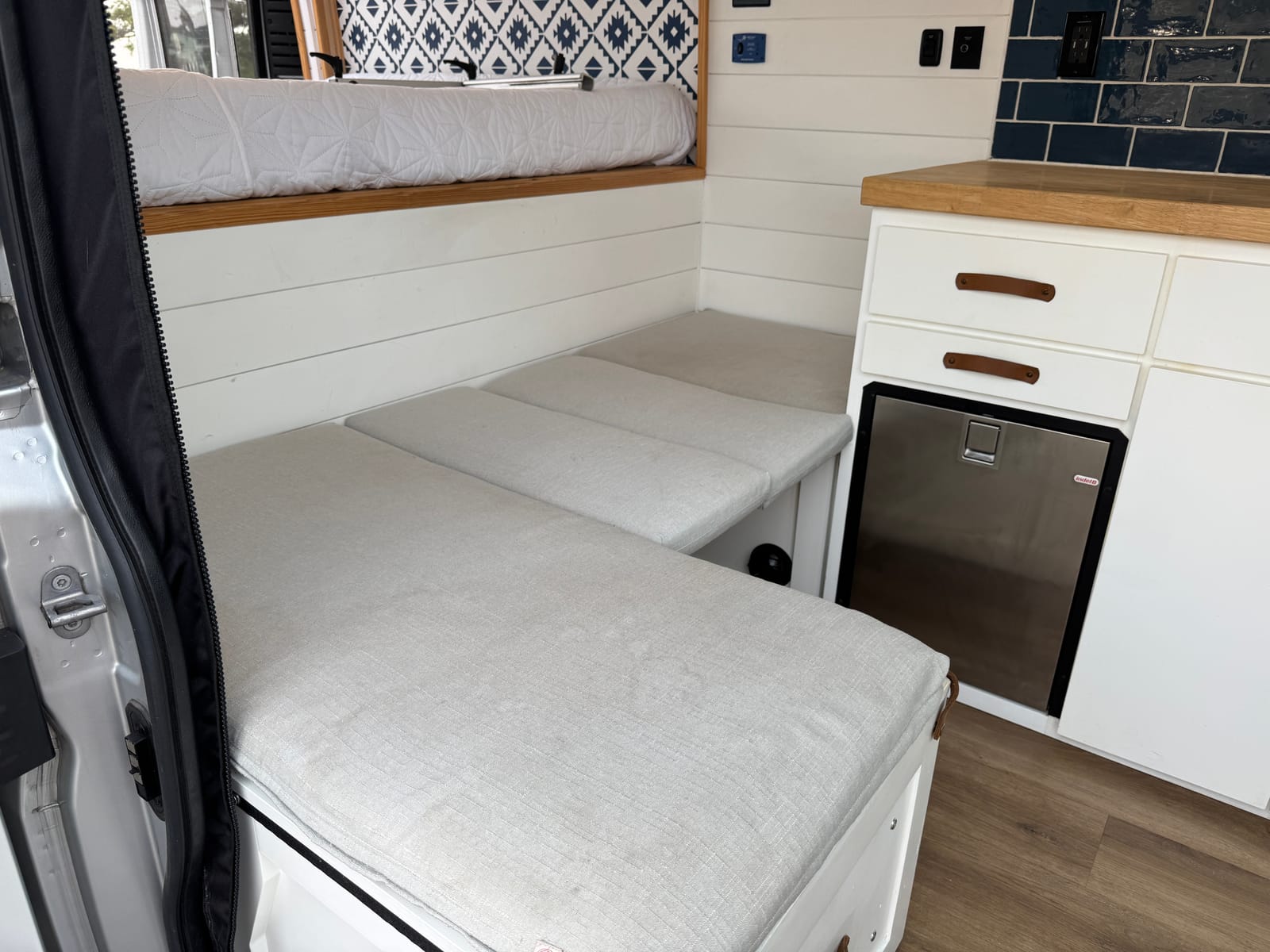Convertible lounge with the cushions laid flat into a single sleeping surface
