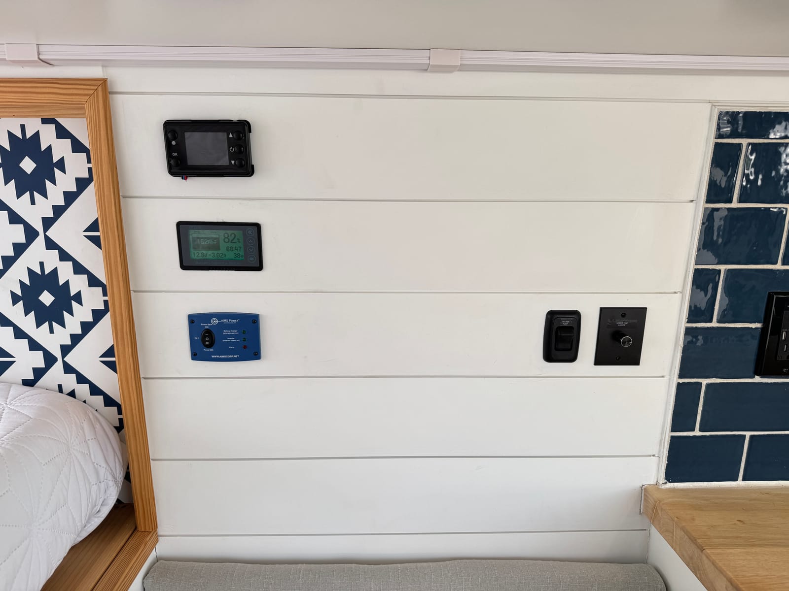 Interior wall control panel and switch bank beside the tile backsplash