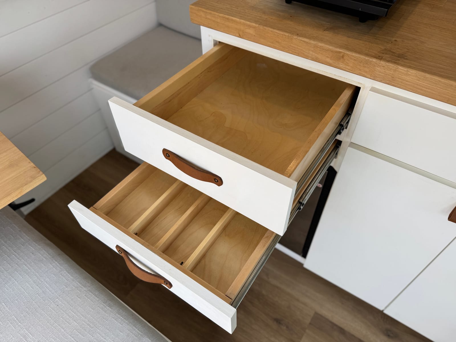 Deep dovetailed storage drawers pulled open below the cabinetry