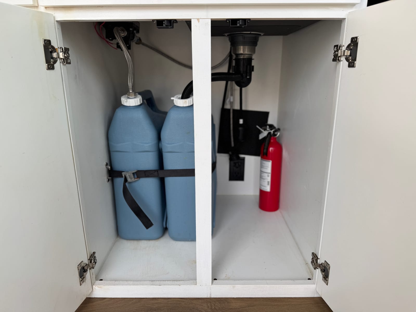 Under-cabinet access to the water jugs and a mounted fire extinguisher