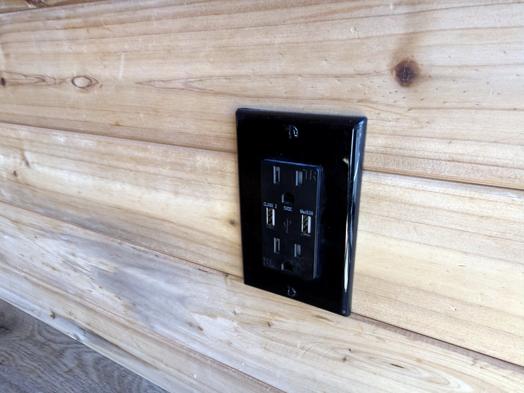 Power outlet with USB ports set into a cedar wall panel