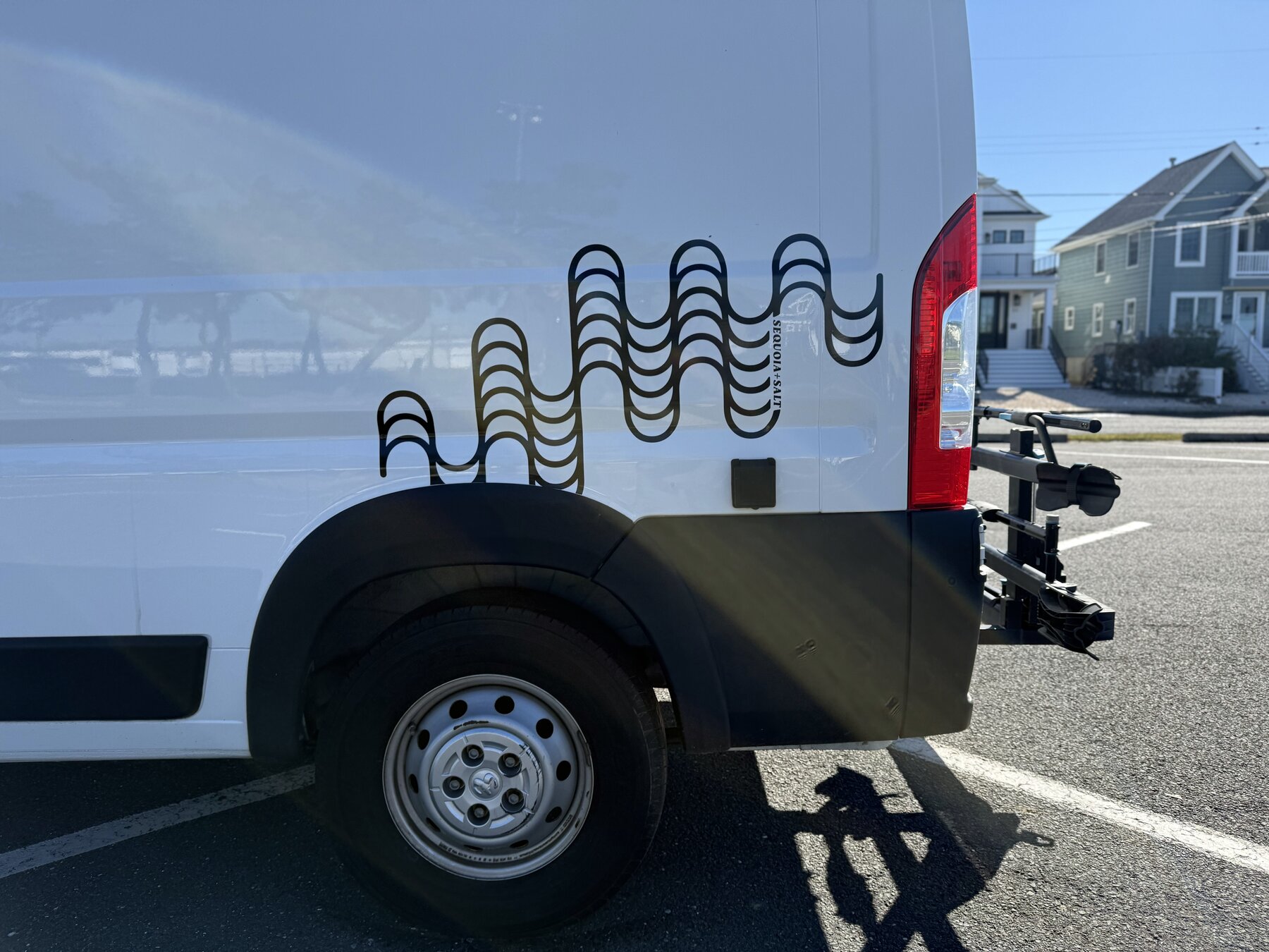 Close view of the rear quarter with the wave graphic and the hitch-mounted bike rack