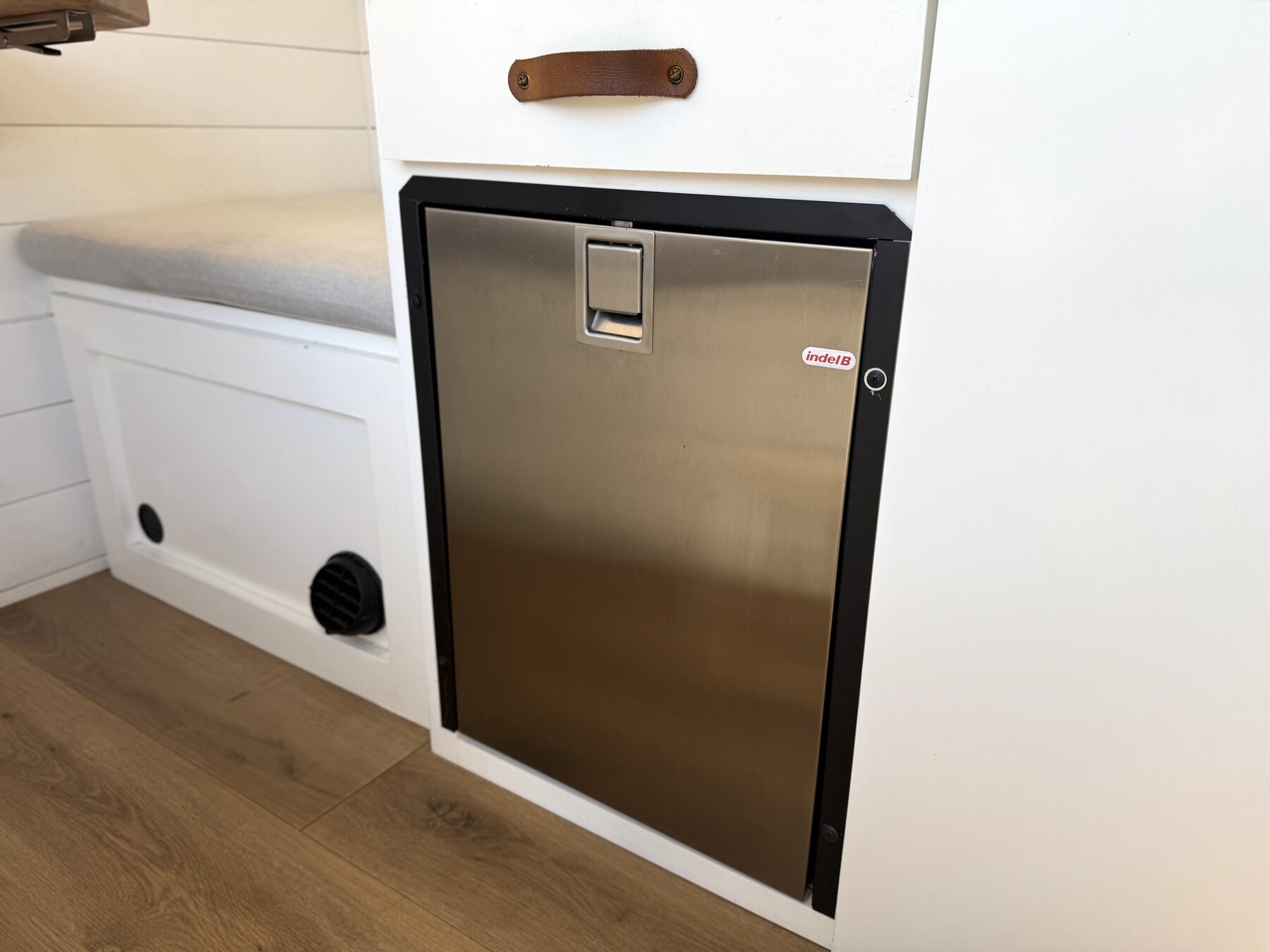 Stainless front-loading fridge built into the galley cabinet