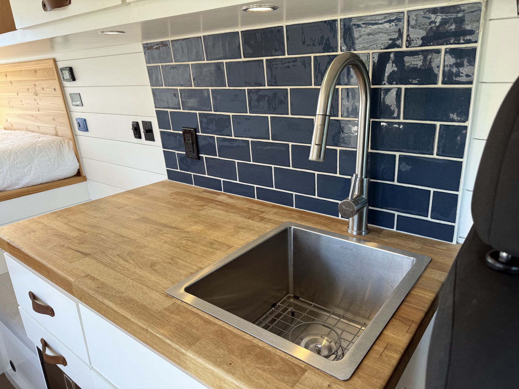 Stainless sink and pull-down faucet set into the butcher block counter