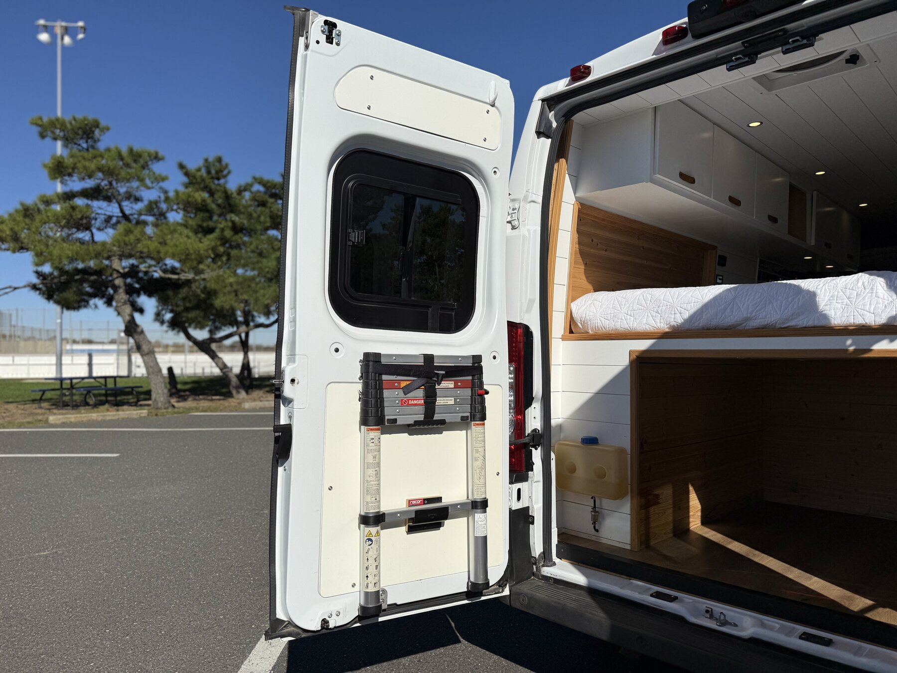 Rear doors open from an angle, with a telescoping ladder mounted on the inside of the door