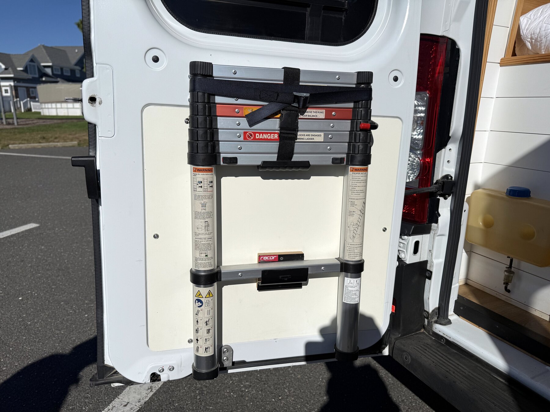 Telescoping ladder strapped to the inside of a rear door