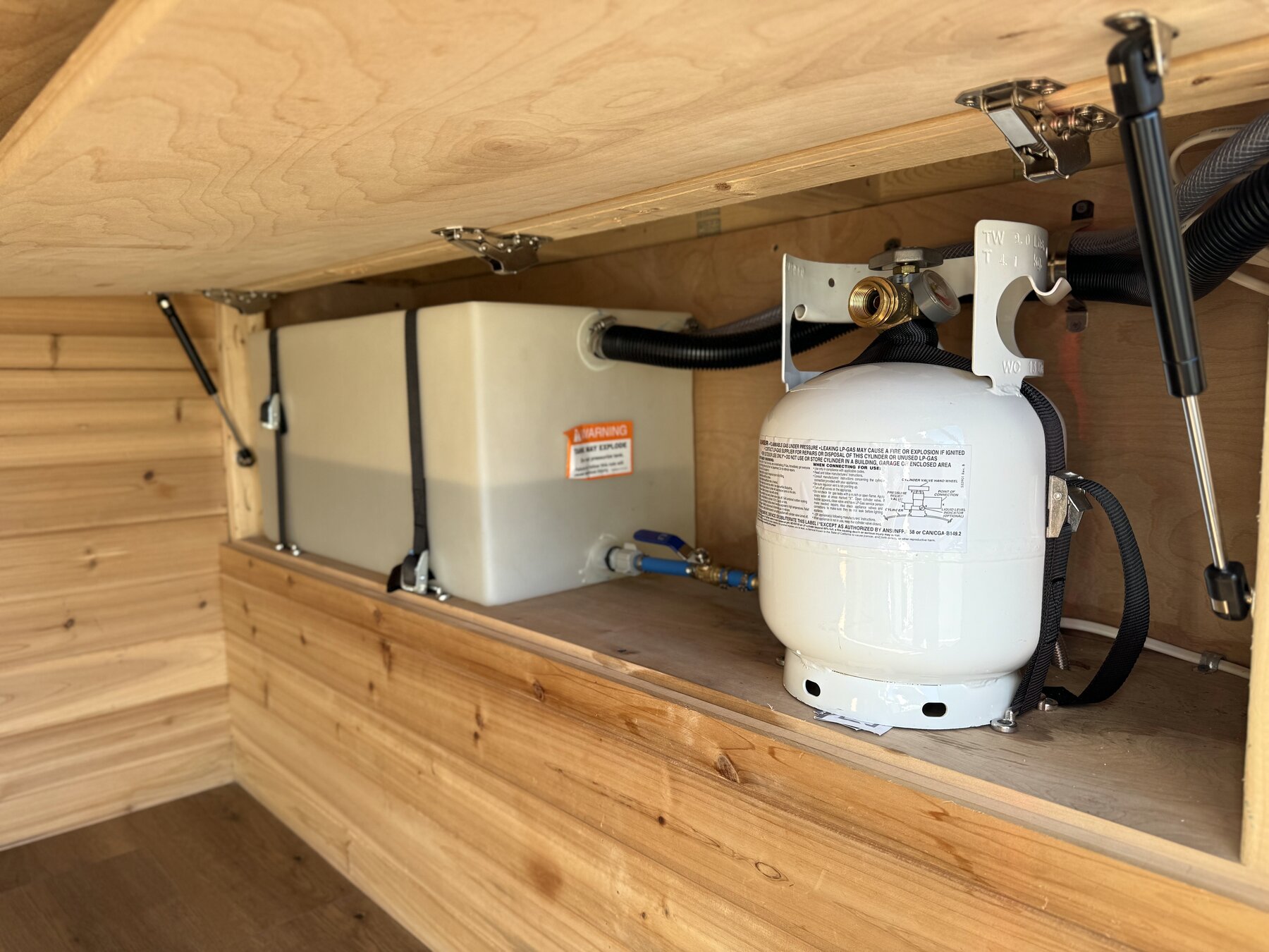 Fresh water tank and propane cylinder in the compartment under the bed