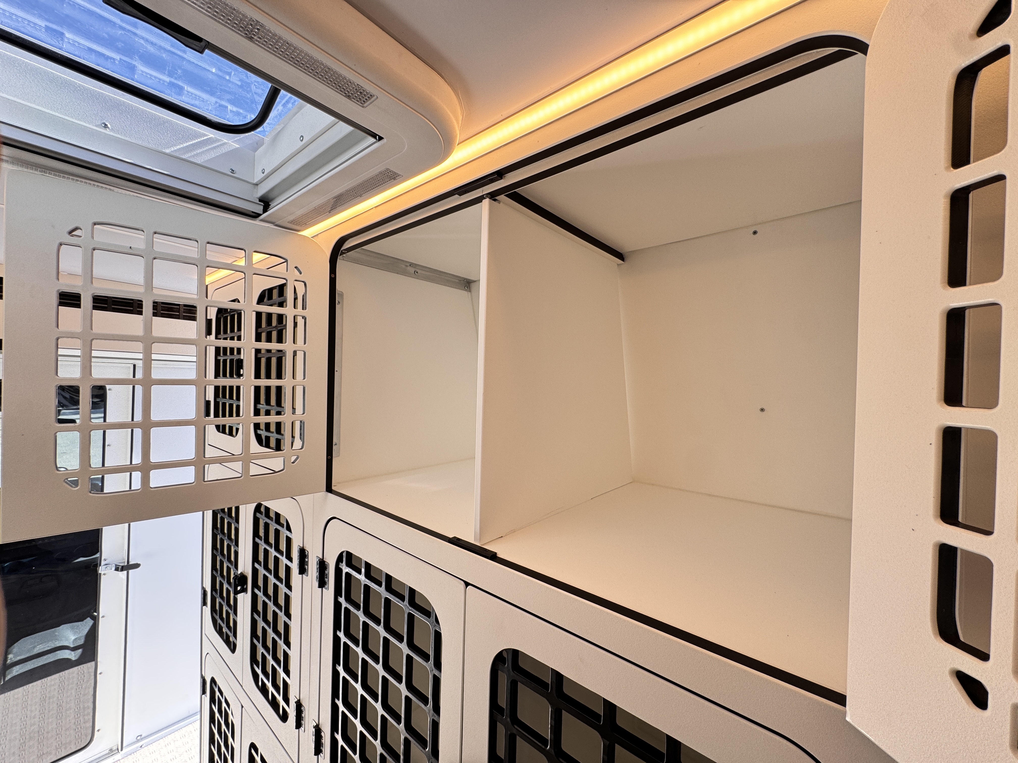 K9 transport Sprinter — top-row kennel with door open showing interior volume