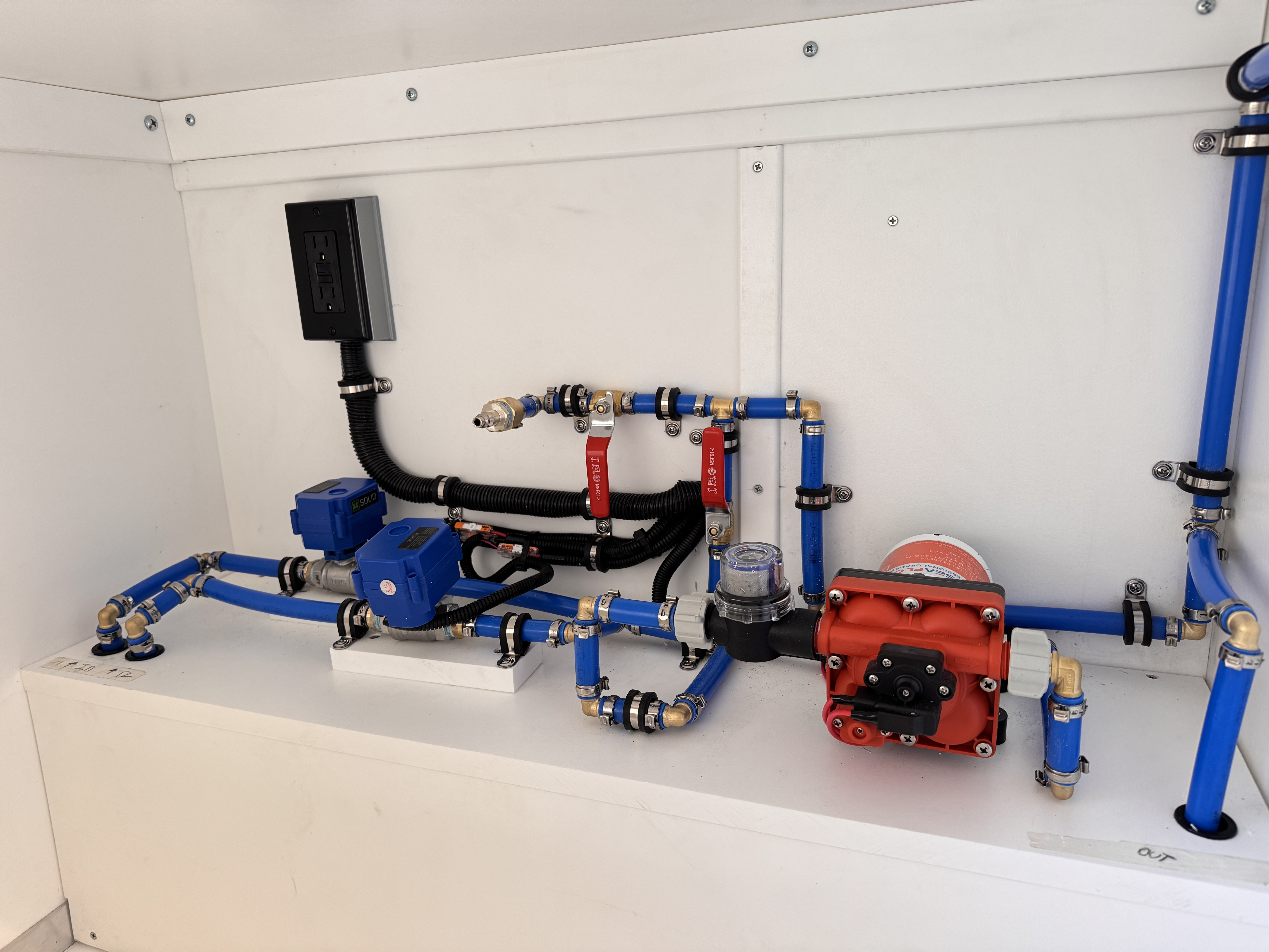 K9 transport Sprinter — Seaflo pressure pump, electric shutoff valves, and PEX manifold inside the water service compartment.