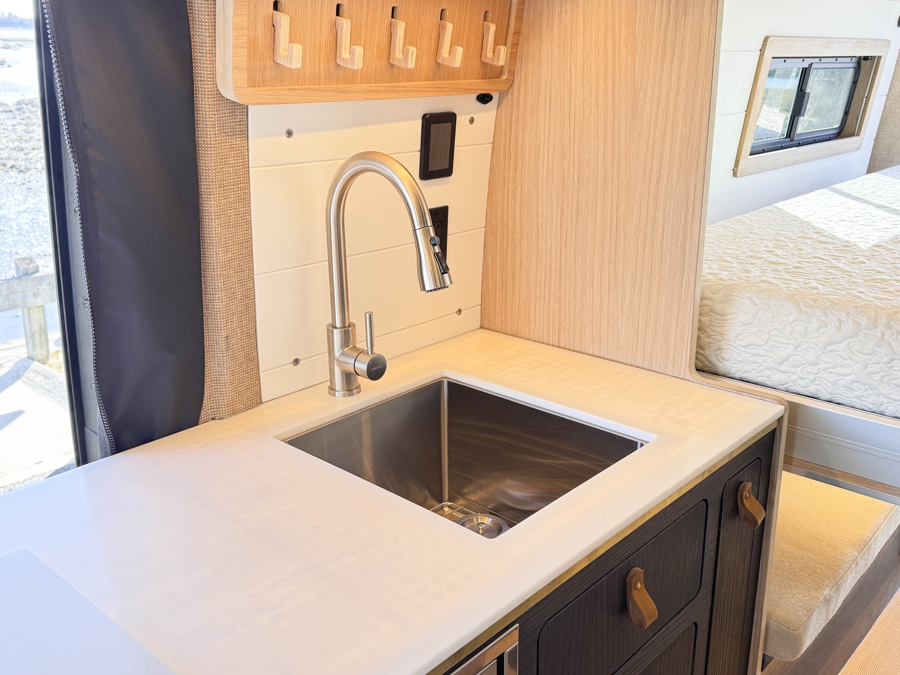Stainless steel galley sink and pull-down faucet detail — fresh water and plumbing install work