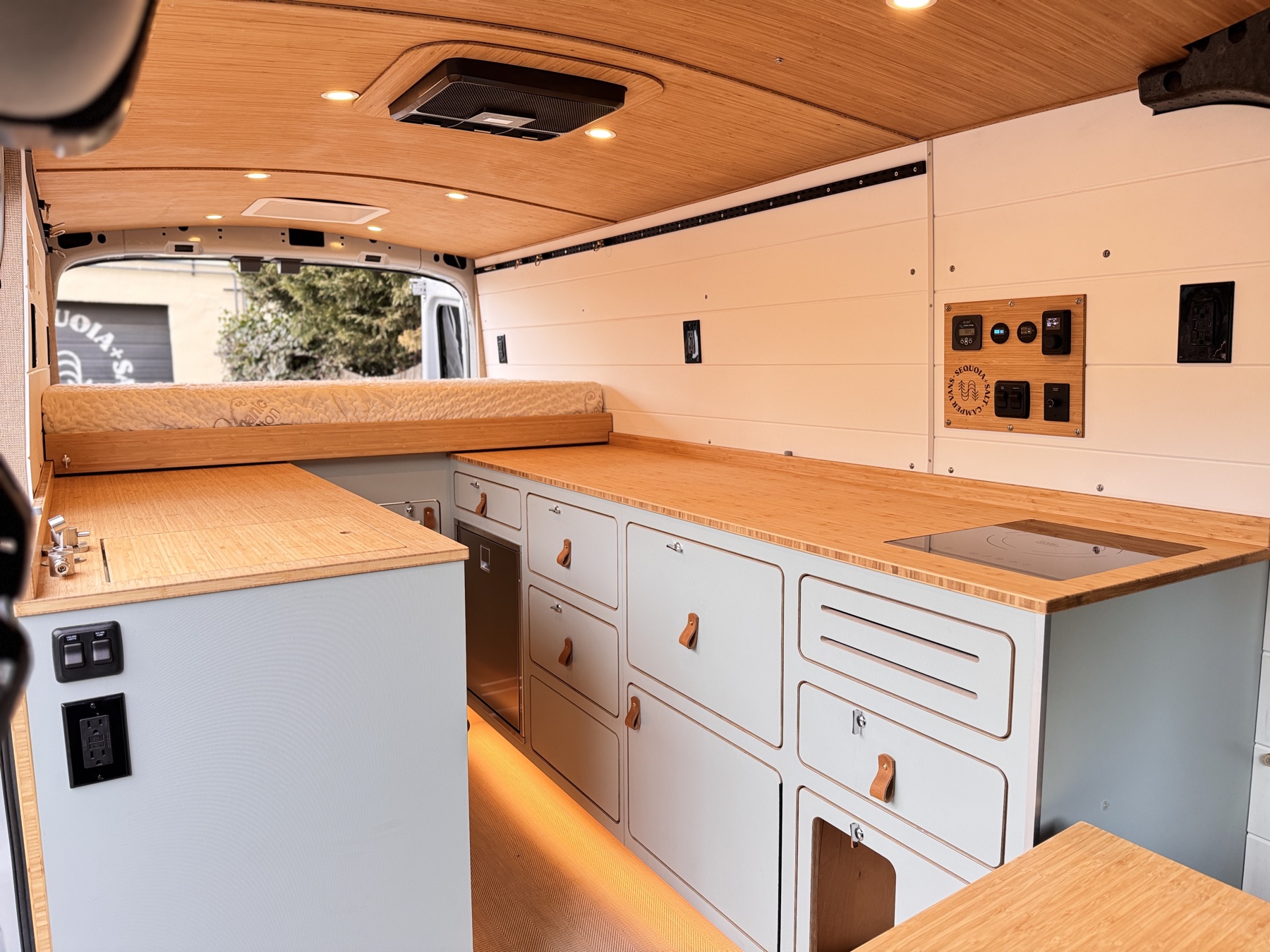 Scout campervan interior — galley, Victron power panel, and finished floor showing the road-ready Foundation systems