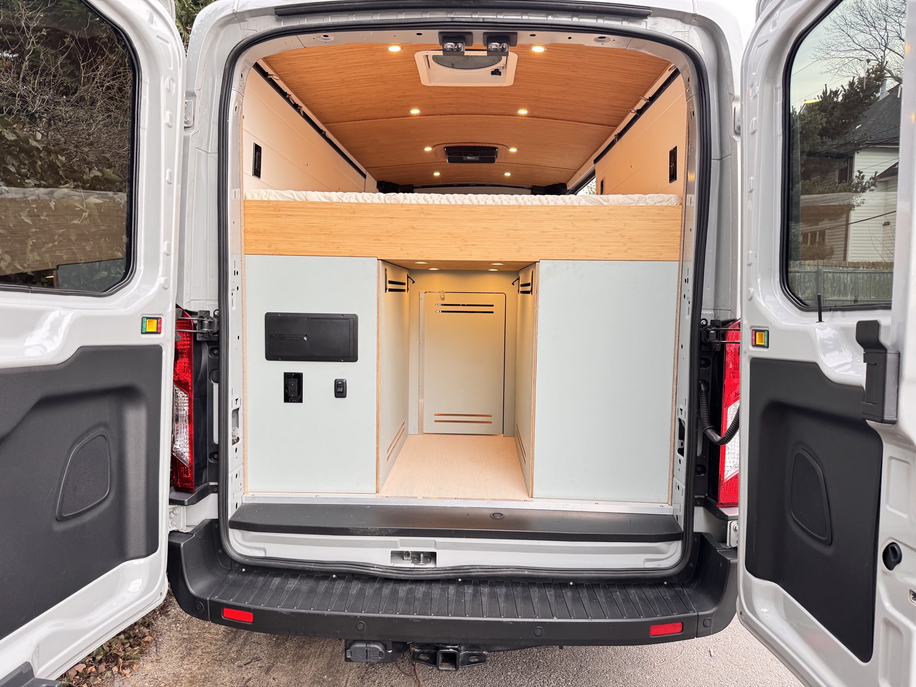 Scout campervan with rear doors open showing gear garage and outdoor shower