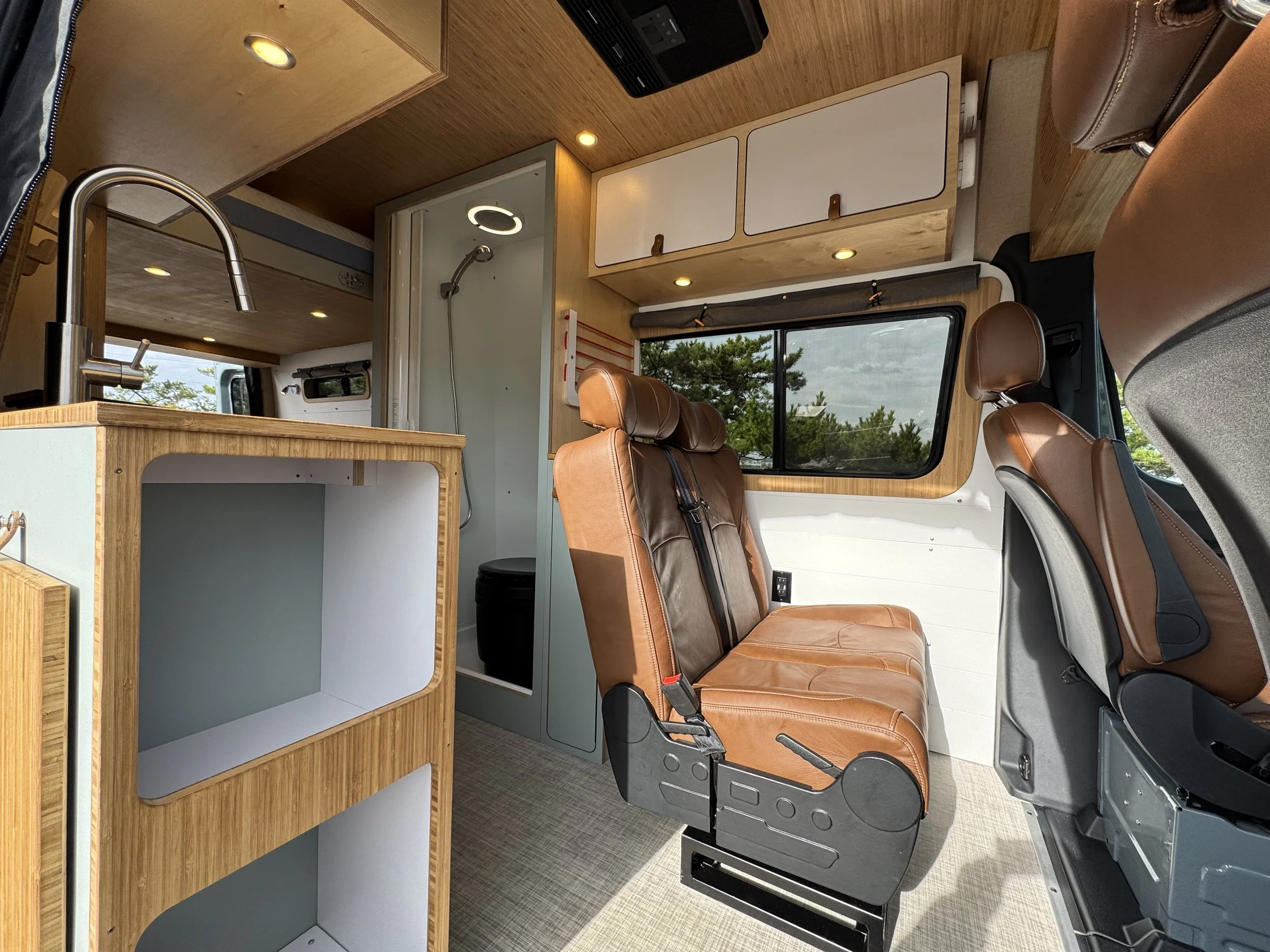 Sprinter campervan interior with jump seats and shower