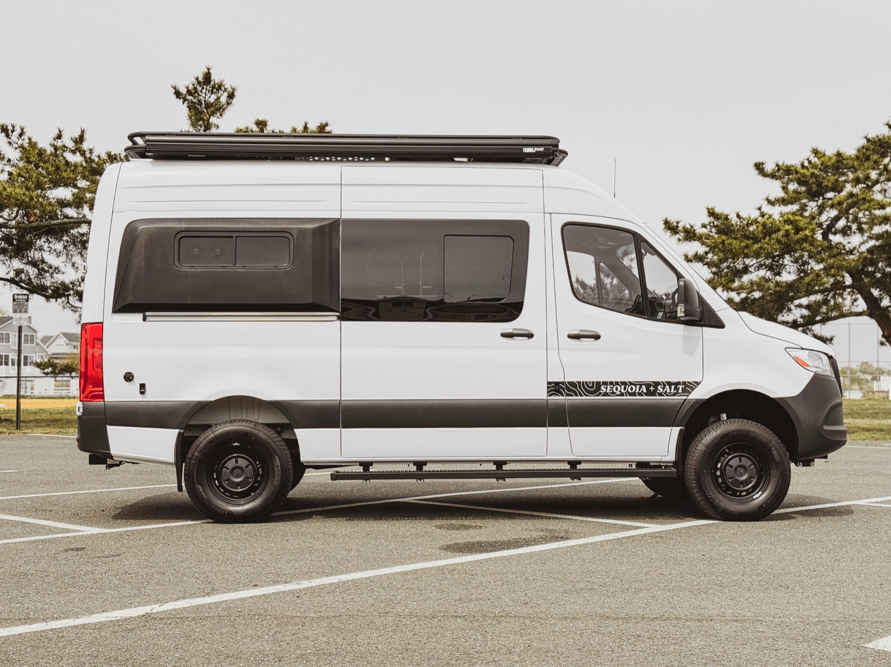 Side profile of a Sprinter camper van with a cassette awning mounted along the roofline